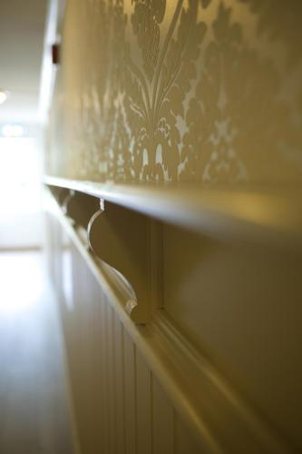 a shelf with a stenciled wallpaper on a wall at Seljord Hotel - Unike Hoteller in Seljord