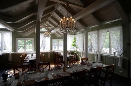 a dining room with tables and chairs and windows at Seljord Hotel - Unike Hoteller in Seljord