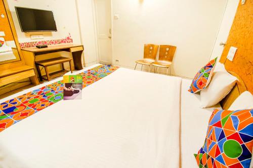 a room with a bed and a desk and a television at FabExpress Karishma - Shivaji Nagar, Pune in Pune