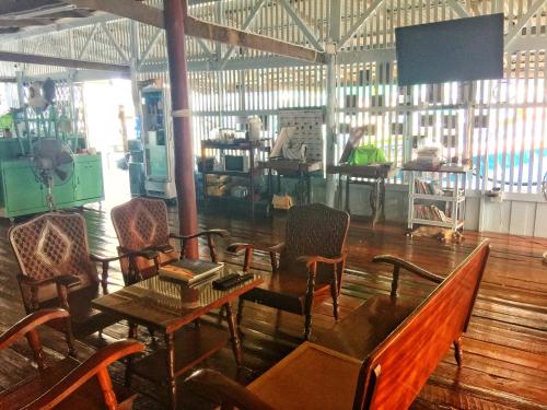 a room with chairs and a table and a person working at Rub Lom Chom Klong Homestay in Chumphon