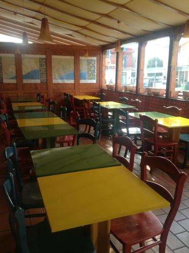 a dining room with yellow tables and chairs at Alloggi Taverna Caorlina in Caorle