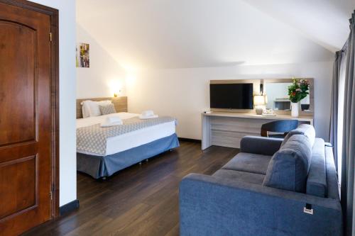 a hotel room with a bed and a couch at Hotel Antonio in Uzhhorod