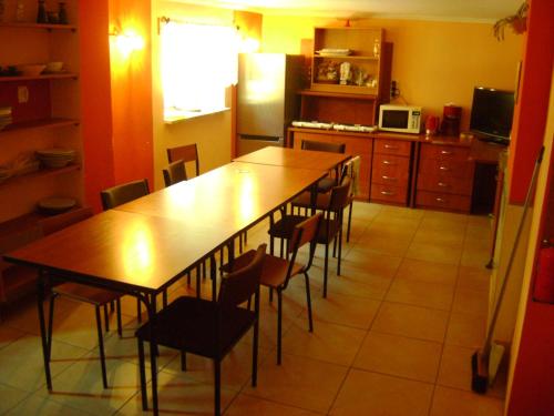 a kitchen with a large wooden table and chairs at Hostel Promyk in Iwonicz-Zdrój