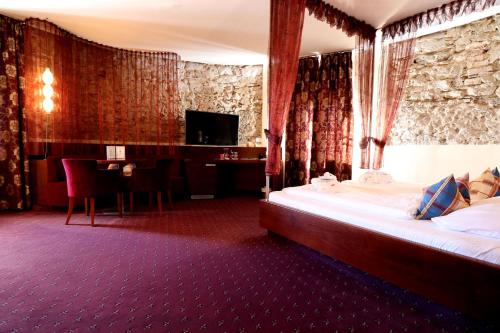 a hotel room with a bed and a desk and a television at Hotel Öhlknechthof in Horn