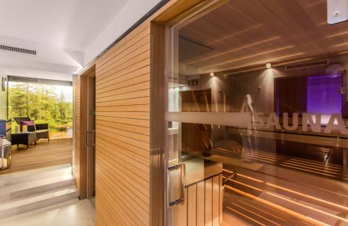 a living room with a sliding glass door with a tv at Hotel Garni Edelweiss in Lech am Arlberg
