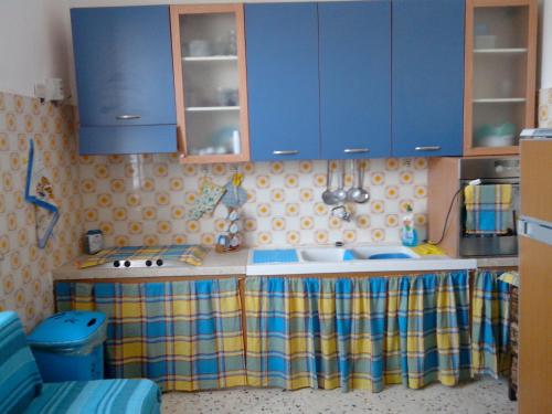 uma cozinha com armários azuis e uma bancada em villa Maria em Favignana