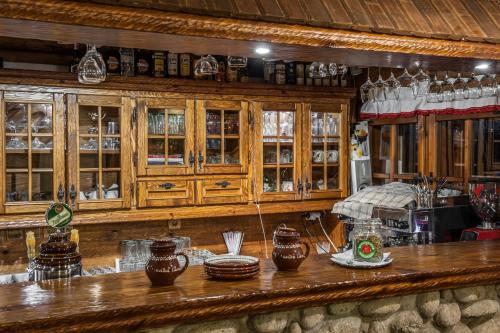 a kitchen with wooden cabinets and a counter with dishes at Koliba Likava in Likavka