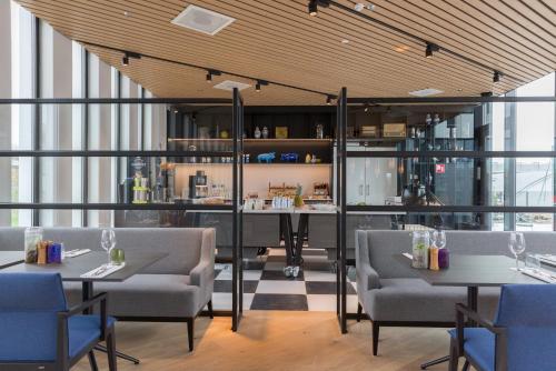 a restaurant with tables and chairs and a bar at Postillion Hotel Amsterdam in Amsterdam