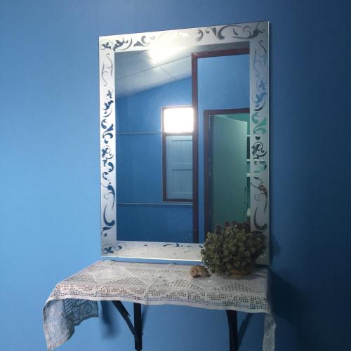 a mirror on a table with a plant on it at Rub Lom Chom Klong Homestay in Chumphon