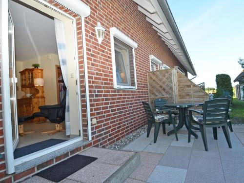 un patio con mesa y sillas fuera de un edificio en Ferienhaus Lobbe - Wohnung 04 mit Terrasse strandnah en Lobbe