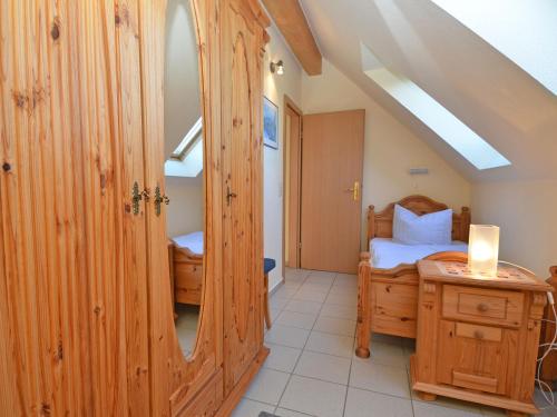 a small bedroom with a bed and a mirror at Ferienhaus Lobbe - Wohnung 04 mit Terrasse strandnah in Lobbe
