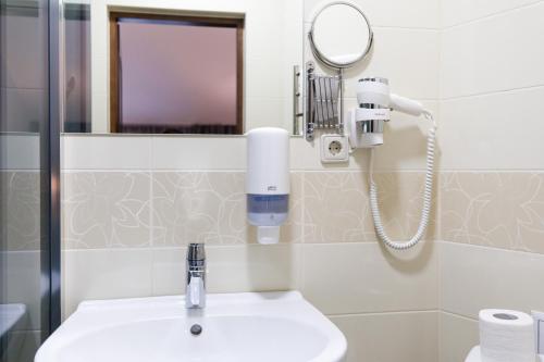 a bathroom with a sink and a mirror at Hotel Antonio in Uzhhorod