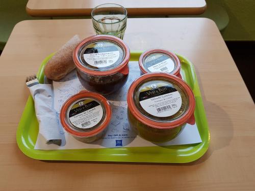 a tray with three jars of jam on a table at Ibis Budget Marseille Valentine in Marseille