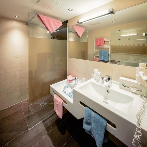 a bathroom with a sink and a mirror at Kinderhotel Laderhof in Ladis
