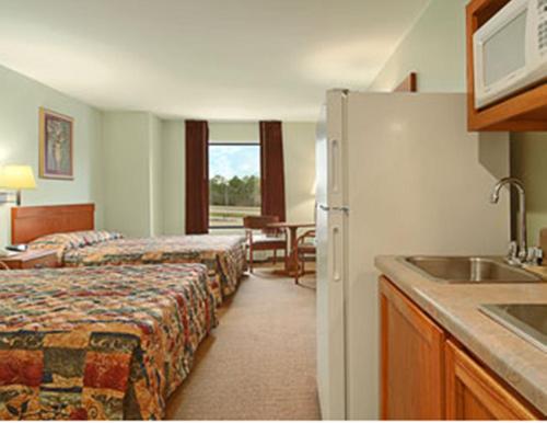 ein Hotelzimmer mit 2 Betten und einem Waschbecken in der Unterkunft Super 8 Pascagoula in Pascagoula