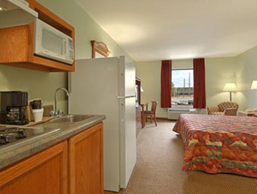 eine Küche mit einem Waschbecken und ein Bett in einem Zimmer in der Unterkunft Super 8 Pascagoula in Pascagoula