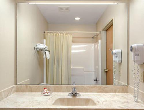 baño con lavabo y espejo grande en Super 8 Pascagoula, en Pascagoula