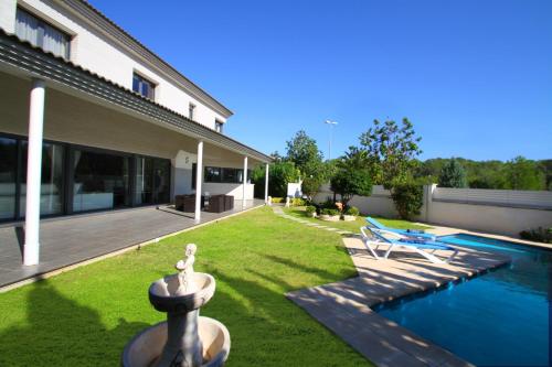 a backyard with a fountain and a swimming pool at ARENDA Villa Perla in Hospitalet de l'Infant