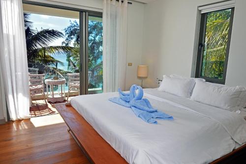 a large white bed with a blue towel on it at RESIDENCE KOT NOR in Pereybere