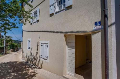 ein Gebäude mit einer Garage mit einer Tür in der Unterkunft Mediterranes Ferienhaus m. Terrasse in Veli Lošinj