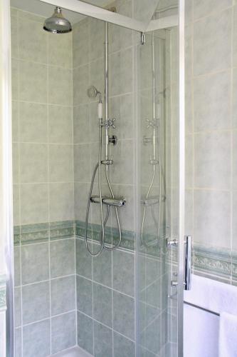 une salle de bain avec une douche avec une porte vitrée dans l'établissement Maison Boulvern, à Plomodiern