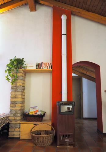 a wood stove in a room with a fireplace at Bed & Breakfast Ligont in Budòio