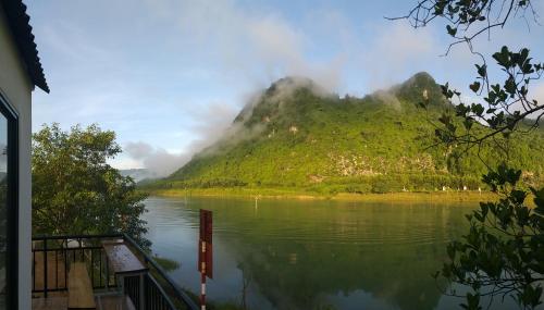 a mountain sitting next to a body of water at Charm's Homestay in Phong Nha