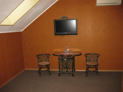 a dining room table with chairs and a television at Transit Hotel in Dʼyakovtsy