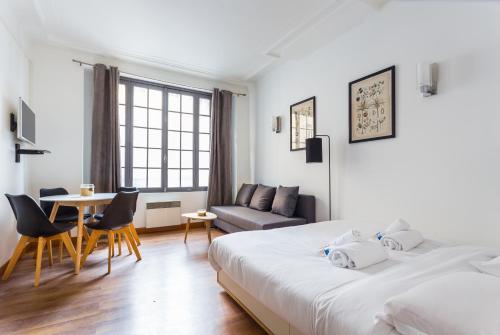 1 Schlafzimmer mit 2 Betten, einem Tisch und einem Sofa in der Unterkunft CMG Palais des Congrès/ Ternes in Paris