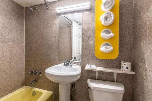 a bathroom with a sink and a toilet and a mirror at Motel 6-Elmsford, NY - White Plains in Elmsford