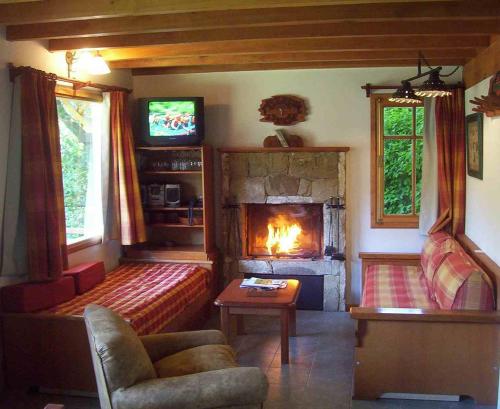 a living room with a fireplace and a couch at Cabañas Temporada in San Martín de los Andes