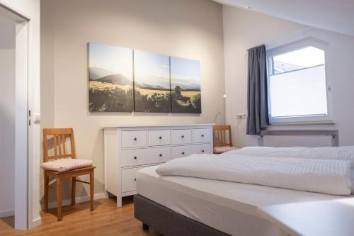 ein Schlafzimmer mit einem Bett, einer Kommode und einem Fenster in der Unterkunft Ferienwohnung Stern in Friedenweiler