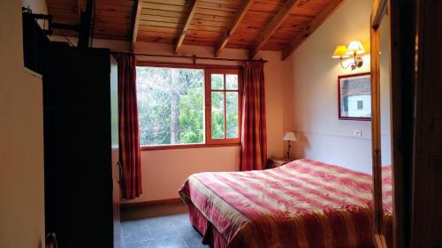 a bedroom with a bed and a window at Cabañas Temporada in San Martín de los Andes
