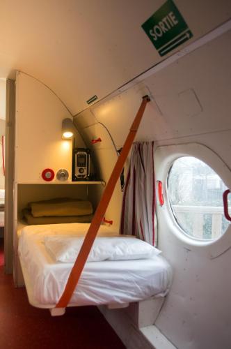 une petite pièce avec un lit et une fenêtre dans l'établissement Camping Insolite Le Haut Village, à Saint-Michel-Chef-Chef