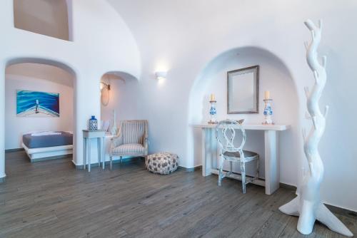 a room with white walls and a table and chairs at Angel Luxury Suites in Fira