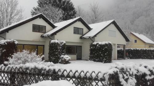 a house covered in snow with a fence at Ferienhaus Döbriach am Millstätter See in Döbriach