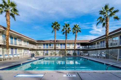 a pool in front of a hotel with palm trees at Motel 6-El Centro, CA in El Centro
