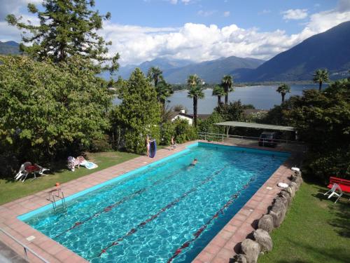 a swimming pool with a view of a lake and mountains at Residenza Paradiso di Vacanze in Locarno