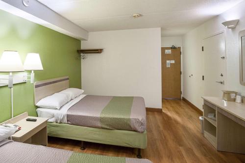 a small hotel room with a bed and a bathroom at Motel 6-Binghamton, NY in Binghamton