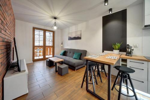 a kitchen and living room with a couch and a table at Apartamenty Sun Seasons 24 - Leśny Dom in Karpacz