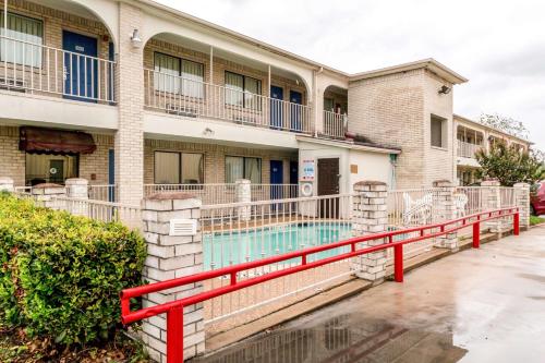 a building with a swimming pool in front of a building at Motel 6 San Antonio, TX - Frost Bank Center in San Antonio