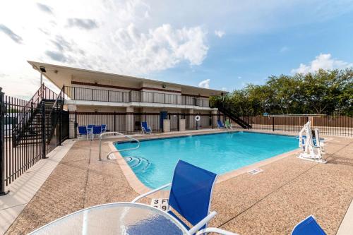 a swimming pool with blue chairs and a building at Motel 6-San Antonio, TX - South IH-10 East in San Antonio