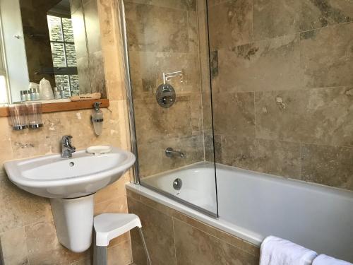 y baño con lavabo, bañera y ducha. en May Cottage B&B en Bowness-on-Windermere