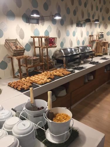 a buffet with plates and food on a table at Hotel Resort Cueva del Fraile in Cuenca