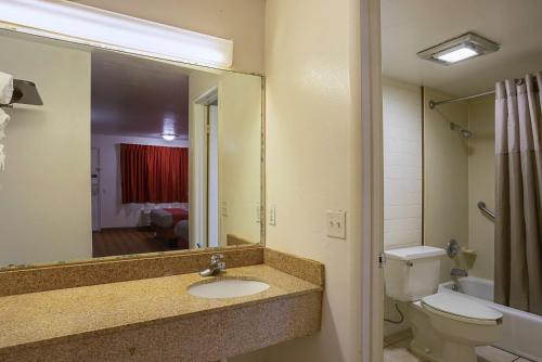 a bathroom with a sink and a toilet and a mirror at Motel 6-Brinkley, AR in Brinkley