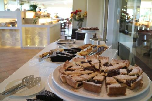 a table with a plate of cake and other desserts at La Bussola Hotel Calabria in Capo Vaticano
