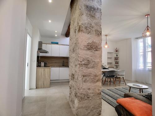 - une cuisine et un salon avec un pilier en pierre dans la chambre dans l'établissement Nestor&Jeeves - HOUSE OF CARDS - Central - Very close sea, à Nice