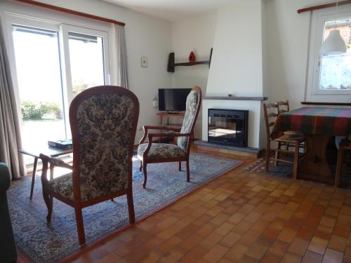 a living room with chairs and a table and a fireplace at Residenza Paradiso di Vacanze in Locarno