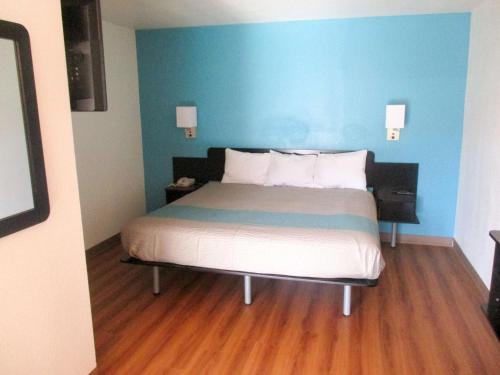 a bedroom with a bed with a blue wall at Motel 6-Prairie Du Chien, WI in Prairie du Chien