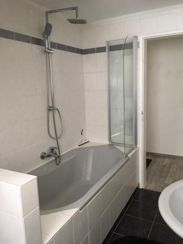 a bathroom with a bath tub and a sink at Zur Burgmauer in Welschbillig